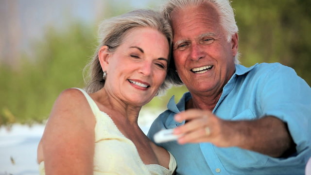 Senior Couple with Technology on Beach