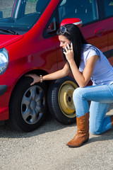 Fototapeta na wymiar Frau mit einer Reifen Panne beim Auto