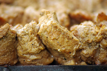 Pieces of marinated pork on barbecue