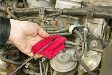 Fototapeta premium Checking engine oil dipstick in the car