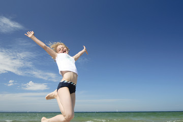 Obraz premium Jumping girl on the beach. Happiness concept