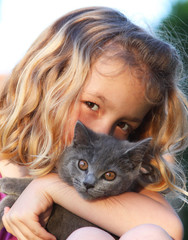 chaton chartreux dans les bras d'un enfant