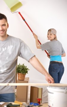 Happy couple painting their home