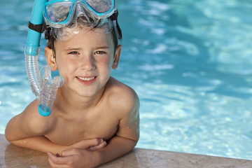 Happy Boy In Swimming Pool With Blue Goggles and Snorkel