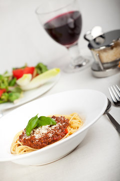 Teller mit Spaghetti Bolognese und Basilikumblatt