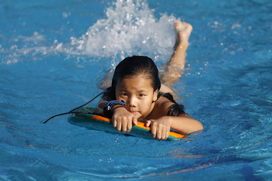 ni&ntilde;a nadando en la piscina