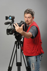 Cameraman in red vest, shows gesture