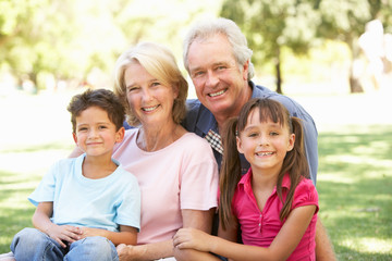 Obraz premium Grandparents And Grandchildren Enjoying Day In Park