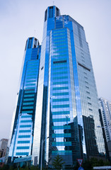 Naklejka premium Highrise glass building with sky and clouds reflection