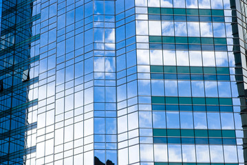 Highrise glass building with sky and clouds reflection