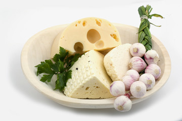 Wooden plate with cheese and garlic isolated