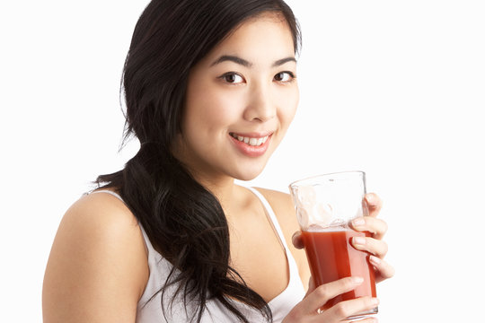 Young Woman Enjoying Healthy Drink In Studio