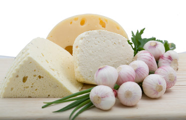 Wooden plate with cheese and garlic isolated