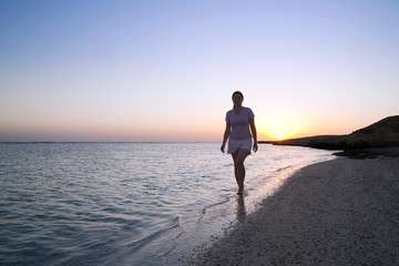 Fototapeta na wymiar girl at coast sea during sunrise
