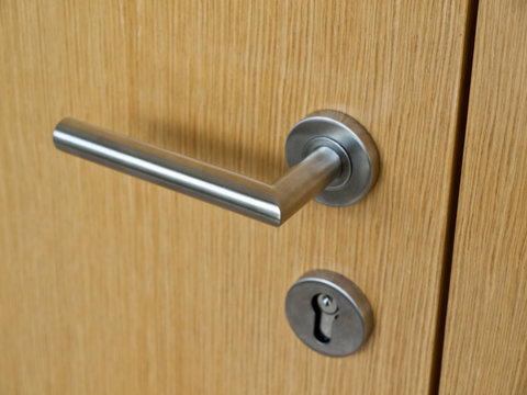Door handles on wood wing of door and keyhole