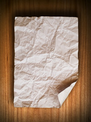 Crumpled paper on wood wall