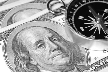 Macro shot of compass with 100 dollar bill Ben Franklin