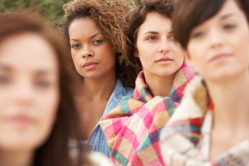 Obraz premium Close Up Of Group Of Girls Sitting On Beach Together