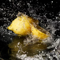 Foto op Canvas zoet water druppels op citroen op zwarte achtergrond © REDSTARSTUDIO