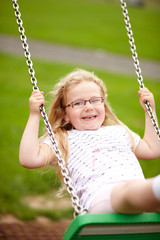 Mädchen schaukelt auf Spielplatz