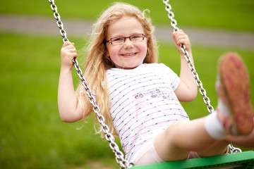 Mädchen schaukelt auf Spielplatz