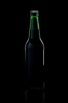 a green bottle beer over black background with shadow