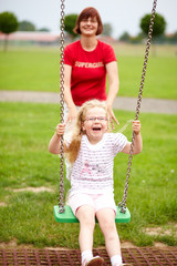 M&auml;dchen schaukelt auf Spielplatz