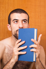 man reading a book on the bed