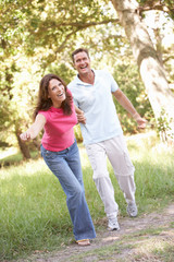 Fototapeta premium Portrait Of Young Couple Walking In Park