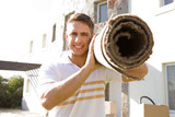Portrait of a man carrying a carpet