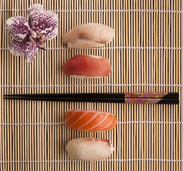Sushis et orchidée sur un tapis de bambou
