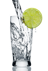 Fototapeta na wymiar Water flowing in a glass with a lemon segment