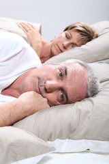 Couple de seniors allongés dans un lit