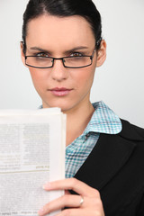 Jeune femme lisant un journal