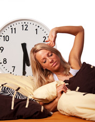 müde Frau streckt sich im Bett