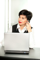 Beautiful woman with a mobile phone and a laptop