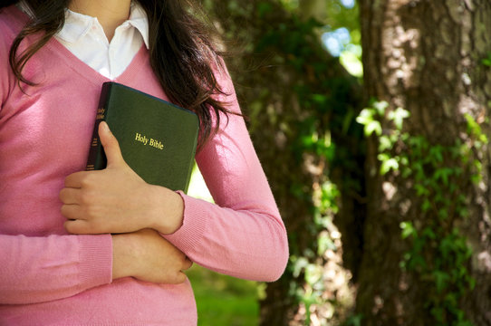 Girl Holding A Bible In Nature