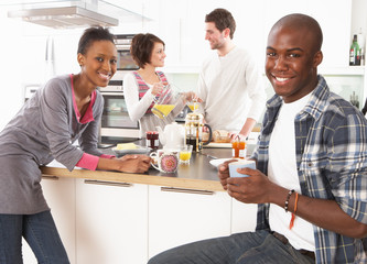 Group Of Young Friends Preparing Breakfast In Modern Kitchen