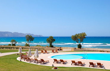 Naklejka premium Swimming pool by beautiful beach and turquoise sea, Crete, Greec