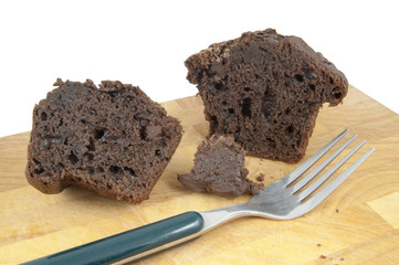 chocolate muffin with fork on chopping board