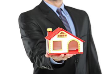 Real estate agent holding a model house in a hand
