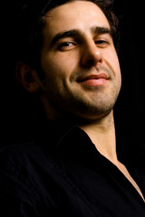 Obraz premium Portrait of young attractive man on a black background