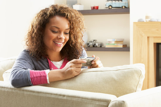 Woman Looking At Pictures On Digital Camera Relaxing Sitting On
