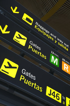 Airport departure gate sign written in English and Spanish