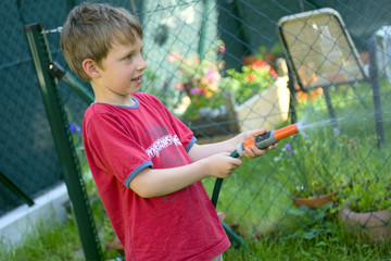 Junge mit Gartenschlauch