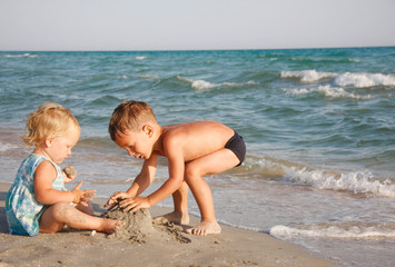 Naklejka premium two kids playing on beach