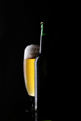 frisches Bier und Flasche auf schwarzem Hintergrund