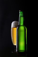 Frisches BIer im Glas und grüne Flasche