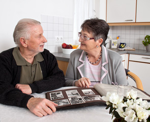 Glückliches Senioren Ehepaar sieht Fotoalbum an.