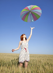 Fototapeta premium red-haired girl with umbrella at wheat field
